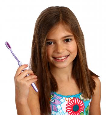 A pretty young girl holding a toothbrush
