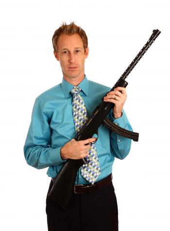 A young businessman holding a rifle