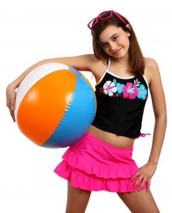 A young girl posing with a beach ball