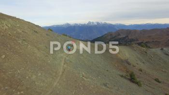 Aerial of mountain bikers riding on mountain slope at dusk ~ Hi Res ...