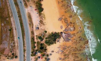 Aerial Photo of Seashore Near Two Lanes of Wide Road