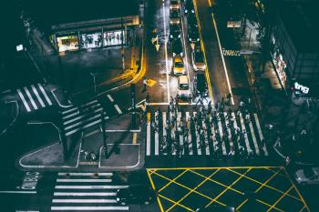 Aerial View of Bunch of People Walking on White Pedestrian Lane during Night