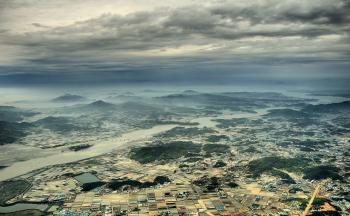 Aerial View Photo of Urban Area and Mountain Range in the Distance Under Gray Cloudy Sky