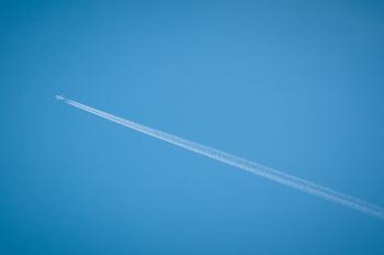 airplane flying through blue sky