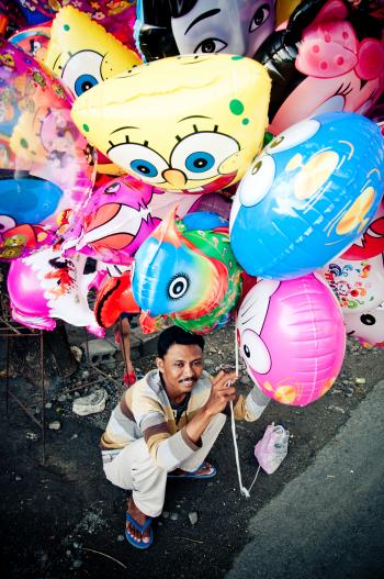 Asian man selling balloons in the street