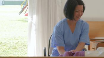 Asian nurse reassuring elderly female patient in hospital bed Stock ...