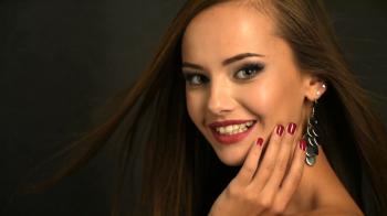 Closeup face of a beautiful smiling girl shows the red nails. Full ...