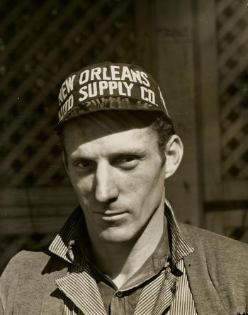 Black and White Photo of Man Wearing New Orleans Supply Hat