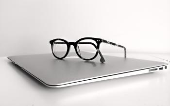 Black Frame Eyeglasses on Silver Macbook Air