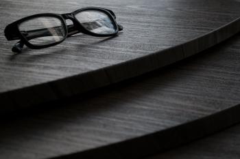 Black Framed Eyeglasses on Brown Surface
