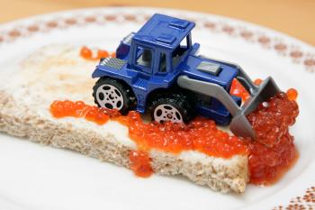 Blue and Gray Excavator on Top of Bread