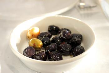 Bowl of Black Olives on a White Table