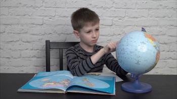 Little boy learning geography - looking at maps and the globe Stock ...
