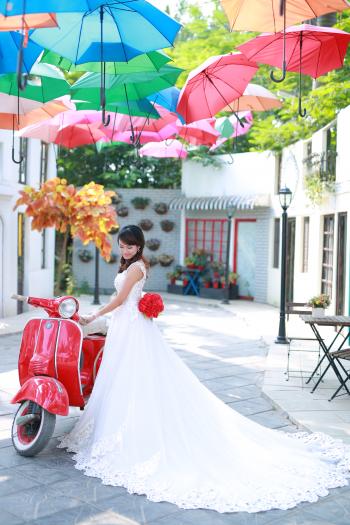 Bride posing with red scooter