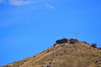 Bright blue sky over the hill with a cross