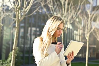 Brown-haired Woman Holding a White Wireless Device