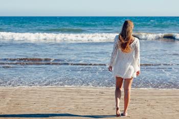 Brown Haired Woman in White Lace Long Sleeve Mini Dress Standing on Seashore