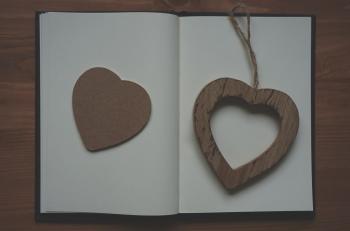 Brown Wooden Heart Shape Pendant on White Book
