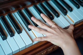 Brown Wooden Piano Used by a Person Using 2 Fingers