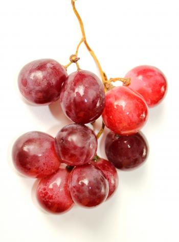 Bunch of red globe grapes on white