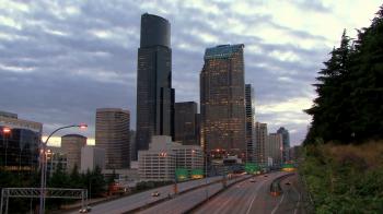 Tall skyscrapers on the city downtown. Cars driving on the freeway ...