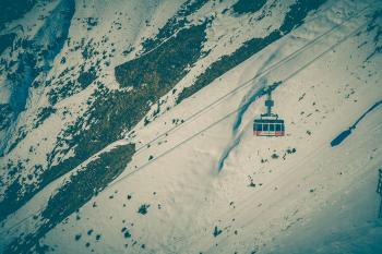 Cable Car Above Snow Covered Mountain