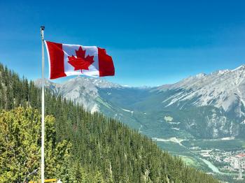Canada Flag With Mountain Range View