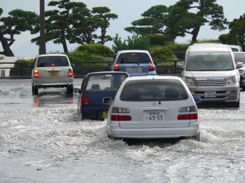 Cars driving on a flooded street in Matsue, Japan