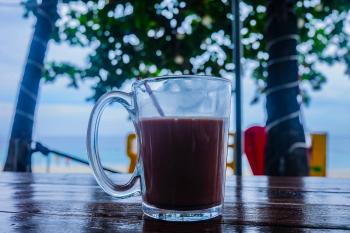 Clear Glass Mug With Beverage on Brown Wooden Table