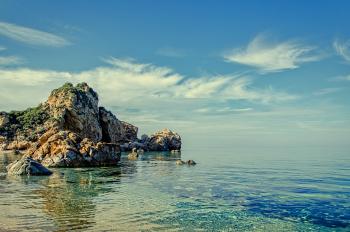 Cliff and Rock Formations on Calm Body of Water during Daytime