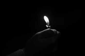Close-up of Hand Holding Candle in Darkroom