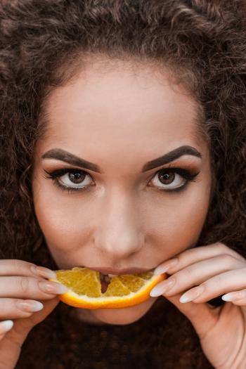 Close-Up Photography of a Woman Eating Orange