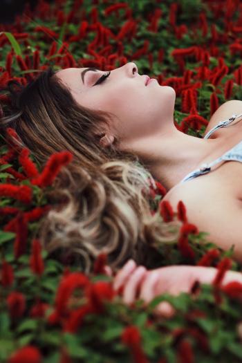 Close-Up Photography of a Woman Laying Near Plants
