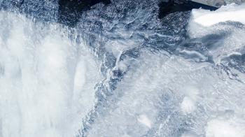 Ice background. Ice surface. Water flow under ice. Closeup. Flowing ...