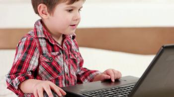 child using laptop, little boy playing computer games using touchpad ...