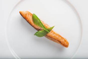 Cooked Fish With Two Green Leaf on Round White Ceramic Plate