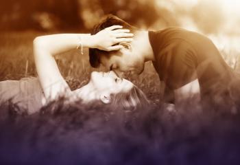 Couple Kissing Laying on the Grass