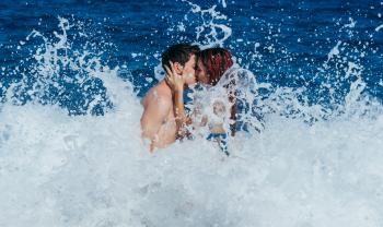 Couple Kissing While Waves Crash