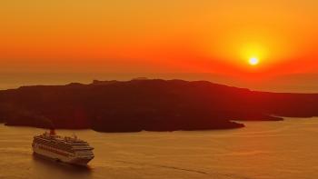 Cruise Ship Traveling on Body of Water Near Island during Golden Hour