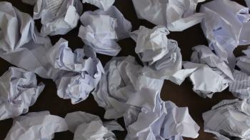 A lot of crumpled papers on a desk, close-up, big failure, effort ...