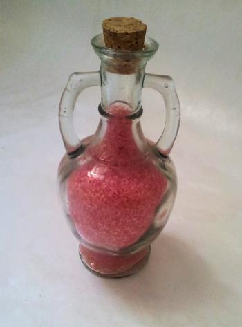 Decorated glass bottle with red bath sal
