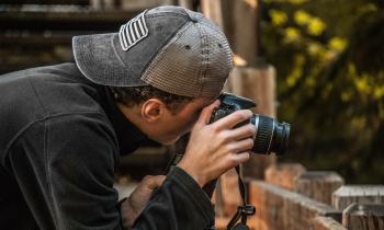 Depth of Field Photography of Man Holding Dslr Camera