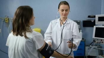 Young adult female doctor checking patient's blood pressure Stock ...