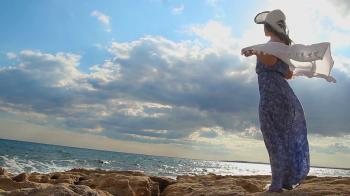 Strong woman standing on sea rocks, enjoying freedom, feeling of ...