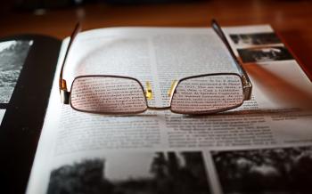 Eyeglasses With Gold-colored Frame on Opened Book