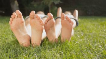 Dolly shot of two girls feet relaxing on grass at sunny day Stock ...