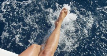 Top view female legs in water Woman splashing and playing with feet ...