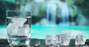 A glass of pure fresh water is poured into a glass, the background ...