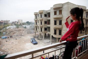 File:A Syrian girl waves from the balcony of an unfinished apartment ...