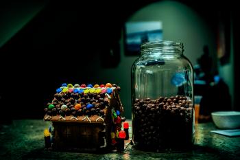 Gingerbread house Near Clear Glass Jar Filled With Candies